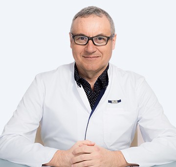 Portrait d'un homme en blouse blanche souriant.